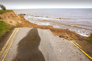 A road eroded and dropping off into the North sea at Happisburgh, Norfolk, a rapidly eroding section of coastline, UK.