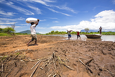 In mid January 2015, a three day period of excessive rain brought unprecedneted floods to the small poor African country of Malawi. It displaced nearly quarter of a million people, devastated 64,000 hectares of alnd, and killed several hundred people. This shot shows a food being ferried across a river near Phalombe after the bridge was washed away.