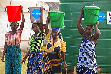 In mid January 2015, a three day period of excessive rain brought unprecedneted floods to the small poor African country of Malawi. It displaced nearly quarter of a million people, devastated 64,000 hectares of alnd, and killed several hundred people. This shot shows a displaced women carrying water in the refugee camp of Chiteskesa refugee camp, near Mulanje.