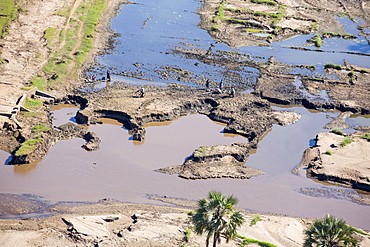 In mid January 2015, a three day period of excessive rain brought unprecedented floods to the small poor African country of Malawi. It displaced nearly quarter of a million people, devastated 64,000 hectares of land, and killed several hundred people. This shot taken from the air shows flood waters and farmland destroyed by the floods, with local farmers crossing their devastated fields.