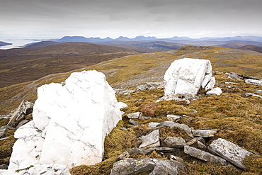 Looking towards the Assynt hills taken from  Eididh nan Clach Geala, Highlands, Scotland, UK, with large quartz boulders in the foreground.