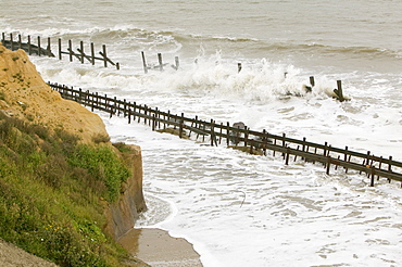 Waves crashing against sea defences at Happisburgh on the fastest eroding section of the UK coast, Norfolk, England, United Kingdom, Europe