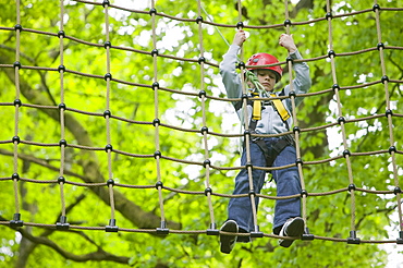 A young boy on a ropes course at Brathay in the Lake District, Cumbria, England, United Kingdom, Europe