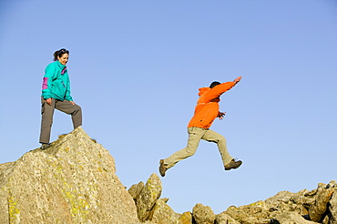 A man and women scrambling on Great Carrs in the Lake District National Park, Cumbria, England, United Kingdom, Europe