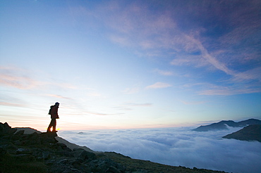 A walker above the clouds on Wet Side Edge in the Lake District National Park, Cumbria, England, United Kingdom, Europe