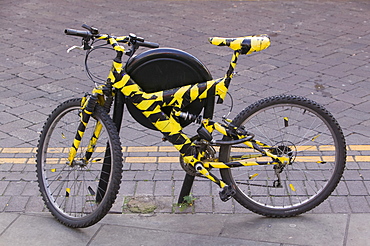 A bike wrapped in black and yellow tape