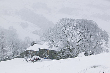 A farmhouse on Kirkstone Pass in the snow above Ambleside, Cumbria, England, United Kingdom, Europe