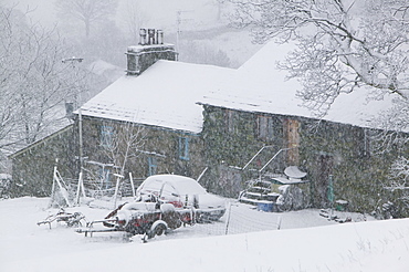 A farmhouse on Kirkstone Pass in the snow above Ambleside, Cumbria, England, United Kingdom, Europe