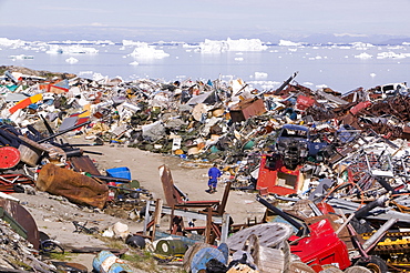 Rubbish dumped on the tundra outside Ilulissat in Greenland with icebergs behind from the Sermeq Kujalleq (Ilulissat Ice fjord), a UNESCO World Heritage Site, Greenland, Polar Regions