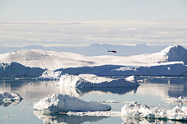 An Air Greenland helicopter flies over the Jacobshavn Glacier (Sermeq Kujalleq) that drains Greenland's ice sheet Greenland, Polar Regions