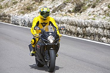 Motorbike rider climbing the Sella Joch pass in the Italian Dolomites, Italy, Europe