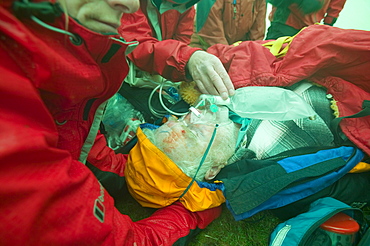 Members of Langdale Ambleside mountain rescue Team treat a collapsed walker suffering from hypothermia protected from the foul weather by a group shelter, Lake District, Cumbria, England, United Kingdom, Europe