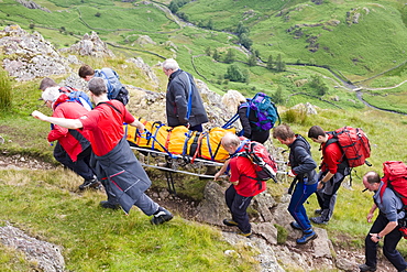 Members of Langdale Ambleside Mountain Rescue Team stretcher an injured walker off Gibson Knott near Grasmere, Lake District National Park, Cumbria, England, United Kingdom, Europe