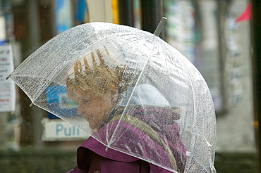 A woman using an umbrella in the rain in Ambleside, Lake District, Cumbria, England, United Kingdom, Europe