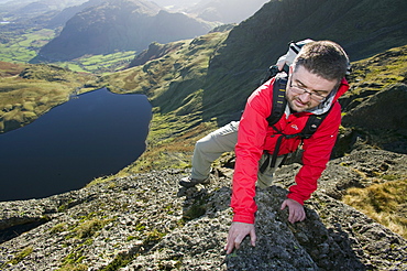 A man scrambling on Pavey Ark in the Lake District, Cumbria, England, United Kingdom, Europe