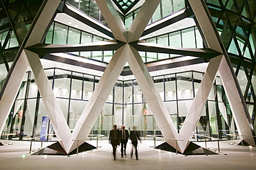 Office workers leaving the Swiss Re Tower at night in London, England, United Kingdom, Europe