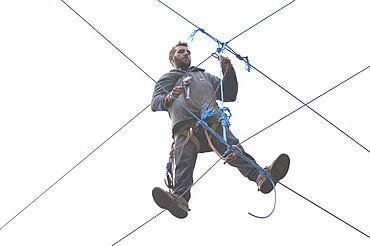 Environmental protestor at the Nine Ladies stone circle camp takes to ropes to avoid bailiffs, Derbyshire, England, United Kingdom, Europe