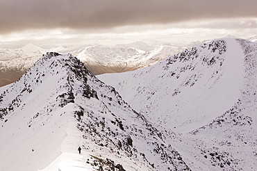 Winter climber ascends An Garbhanach in the Mamore Hills, Scotland, United Kingdom, Europe