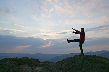 A man practising yoga moves in the mountains of the Lake District, Cumbria, England, United Kingdom, Europe