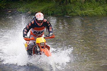 A trail biker crossing a ford in Little Langdale in the Lake District National Park, Cumbria, England, United Kingdom, Europe