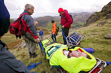 Langdale Ambleside Mountain Rescue Team stretcher an injured hiker off the Langdale Fells in the Lake District, Cumbria, England, United Kingdom, Europe