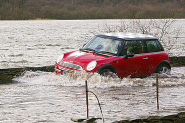 Car splashing through flood water in January 2005 when a severe storm hit Cumbria, England, United Kingdom, Europe