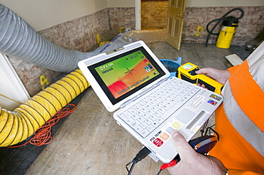 A man uses a thermal imaging camera to test how dried out a Carlisle house is after the floods, Cumbria, England, United Kingdom, Europe