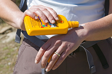 A woman applying sun screen