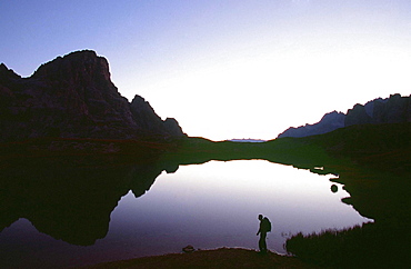 A walker at dawn in the Italian Dolomites, Italy, Europe