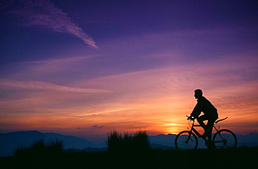 A mountain biker at sunset in the Lake District, Cumbria, England, United Kingdom, Europe