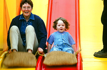 A mother and child on a helter skelter fairground ride