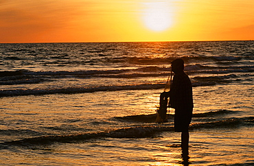 A fisherman with a throw net at sunset, Spain, Europe