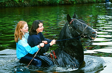 Gypsy girls riding a horse in the River Eden at the Appleby Horse Fair, Cumbria, England, United Kingdom, Europe