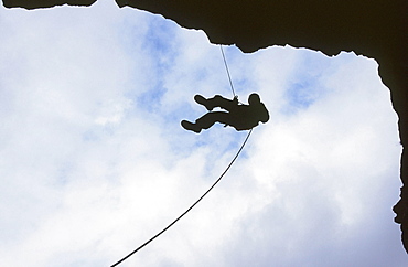 A man abseiling in Rydal Cave in the Lake District, Cumbria, England, United Kingdom, Europe