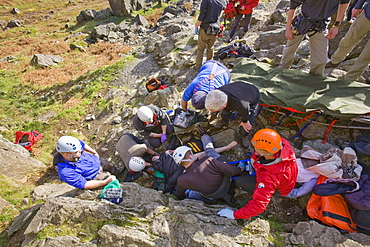 Members of Langdale Ambleside Mountain Rescue Team treat a seriously injured climber with a broken femur in the Langdale Valley, Lake District, Cumbria, England, United Kingdom, Europe