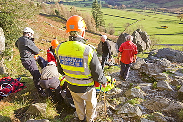 Members of Langdale Ambleside Mountain Rescue Team treat a seriously injured climber with a broken femur in the Langdale Valley, Lake District, Cumbria, England, United Kingdom, Europe