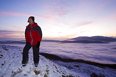 A walker on Wansfell Pike with valley mist below, Lake District National Park, Cumbria, England, United Kingdom, Europe