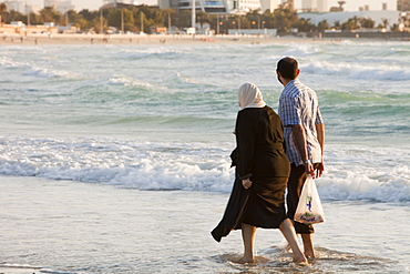 An Arab couple on a public beach in Dubai, United Arab Emirates, Middle East