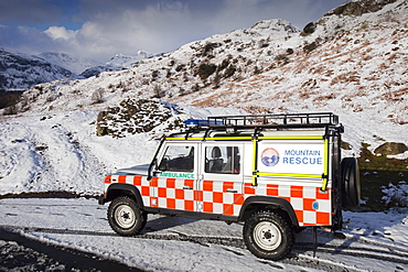 A landrover belonging to the Langdale Ambleside Mountain Rescue Team in winter snow in front of the Langdale Pikes, Lake District National Park, Cumbria, England, United Kingdom, Europe