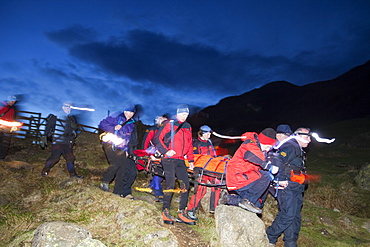 Langdale Ambleside mountain Rescue Team carry an injured walker off the Langdale Pikes at night near Ambleside, Lake District, Cumbria, England, United Kingdom, Europe