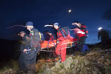 Langdale Ambleside mountain Rescue Team carry an injured walker off the Langdale Pikes at night near Ambleside, Lake District, Cumbria, England, United Kingdom, Europe