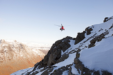 A Navy Sea King helicopter lowers a stretcher to evacuate a seriously injured walker who had fallen 250 feet on Bow Fell in the Lake District, Cumbria, England, United Kingdom, Europe