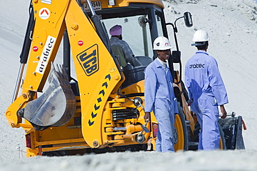 Workers working on reclaiming land from the sea for another exclusive hotel development in Dubai, United Arab Emirates, Middle East