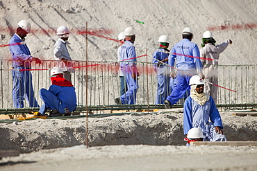 Arab workers working on a reclamation scheme to build another exclusive hotel resort on what was formerly sea bed in Dubai, United Arab Emirates, Middle East