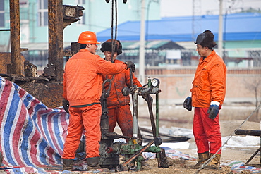 Oil workers drilling a new oil well in the Daqing oil field in Northern China, Asia