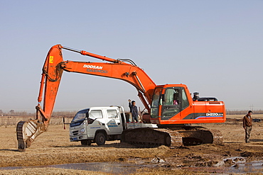 A digger digs deeper into the former lake bed to try and find water, Hong Hai Zai, near Dongsheng, Inner Mongolia, China, Asia