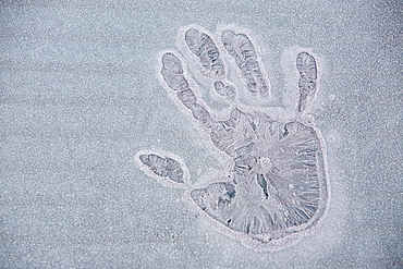 A frozen hand print on an iced over car window in Ambleside, Cumbria, England, United Kingdom, Europe