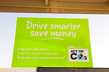 A sign on a petrol pump at a supermarket petrol station advising motorists to drive more efficiently