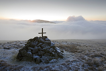 A cross on a cairn near the summit of Caudale Moor at sunset in the Lake District, Cumbria, England, United Kingdom, Europe