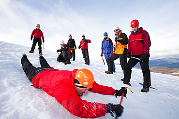 A group of mountaineers practise ice axe arrests on Cairngorm in the Cairngorm National Park in Scotland, United Kingdom, Europe